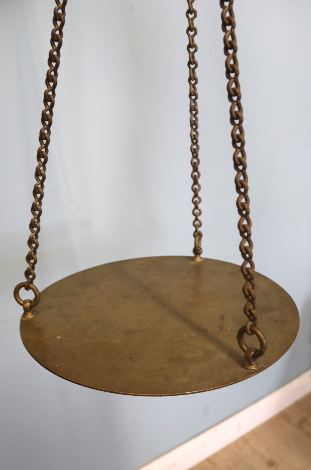 A large hanging brass beam balance scale featuring stamped lettering, suspended chain links, and two circular brass pans. View XXIII