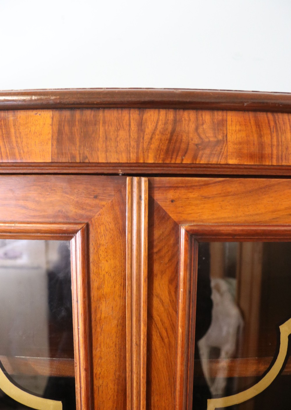 An early 20th-century walnut glazed display cabinet featuring two glass doors with gilded Budweiser advertising signwriting and cabriole legs. View VII