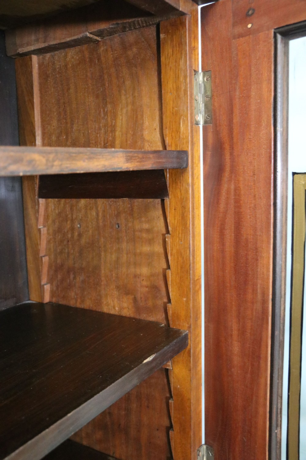 An early 20th-century walnut glazed display cabinet featuring two glass doors with gilded Budweiser advertising signwriting and cabriole legs. View X