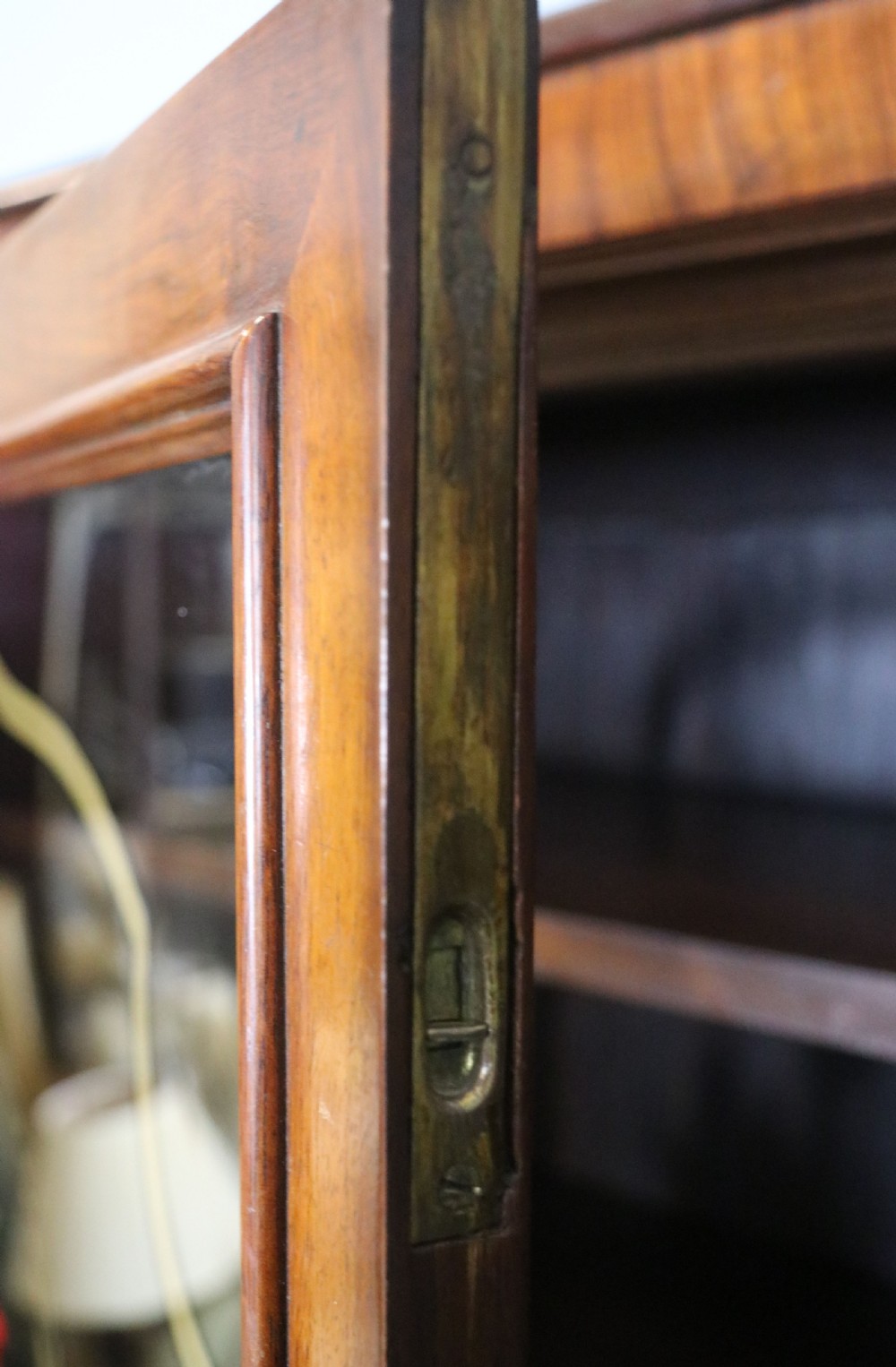 An early 20th-century walnut glazed display cabinet featuring two glass doors with gilded Budweiser advertising signwriting and cabriole legs. View XI