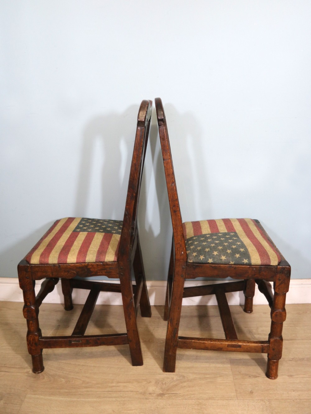 A pair of dark oak side chairs featuring vasiform back splats, turned front stretchers, and seats upholstered in an American flag pattern fabric. View II