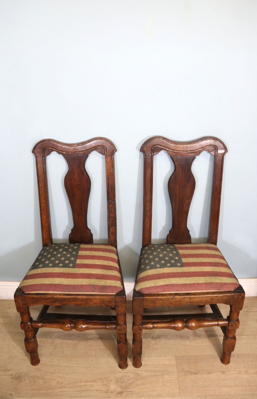 A pair of dark oak side chairs featuring vasiform back splats, turned front stretchers, and seats upholstered in an American flag pattern fabric. View III