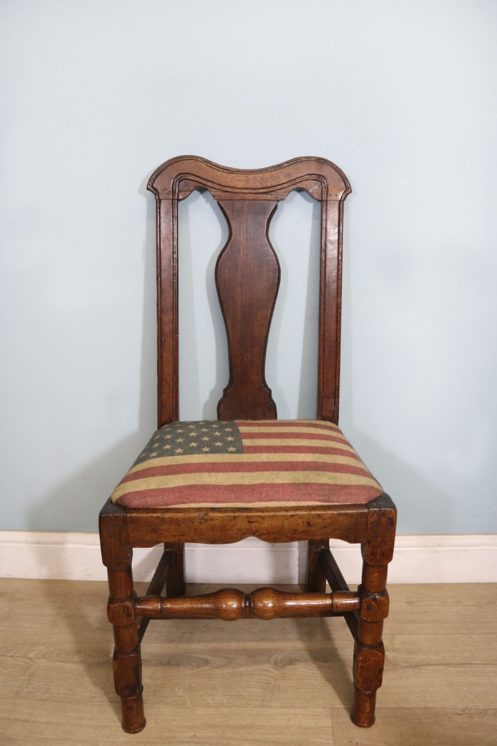 A pair of dark oak side chairs featuring vasiform back splats, turned front stretchers, and seats upholstered in an American flag pattern fabric. View VI