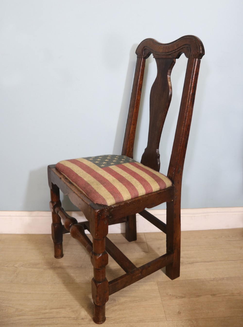 A pair of dark oak side chairs featuring vasiform back splats, turned front stretchers, and seats upholstered in an American flag pattern fabric. View VII