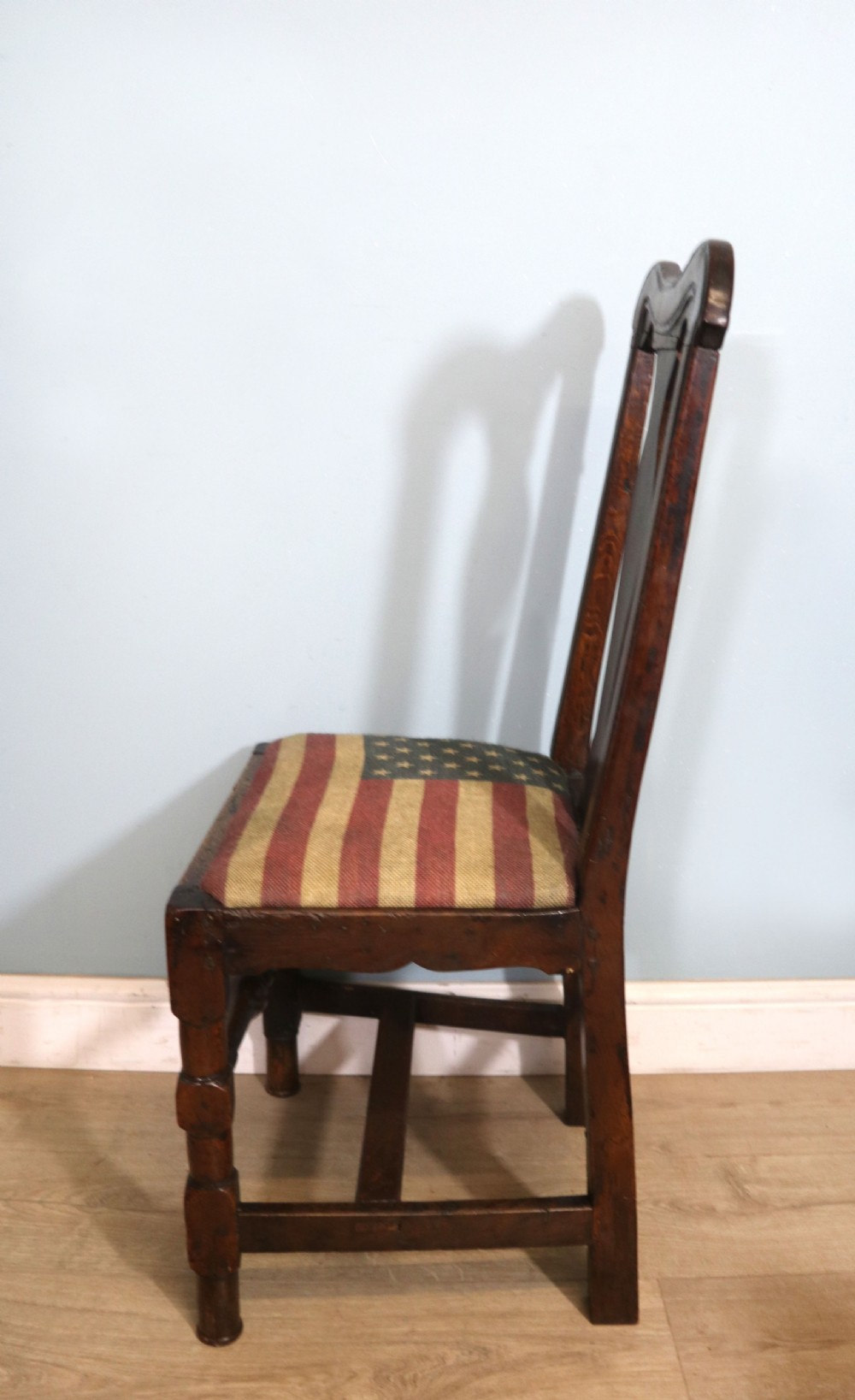 A pair of dark oak side chairs featuring vasiform back splats, turned front stretchers, and seats upholstered in an American flag pattern fabric. View VIII