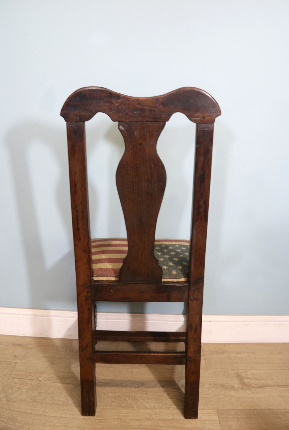 A pair of dark oak side chairs featuring vasiform back splats, turned front stretchers, and seats upholstered in an American flag pattern fabric. View X