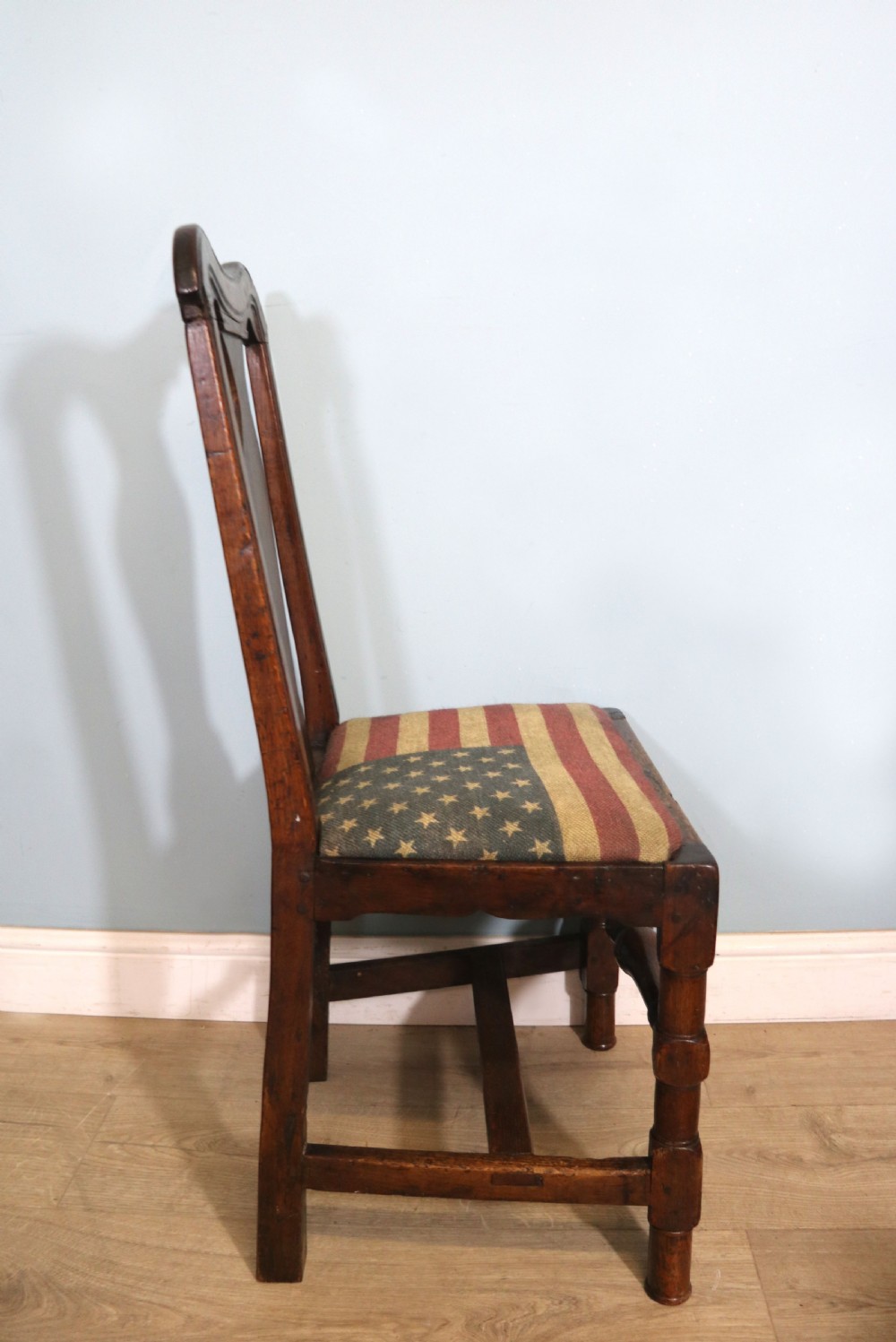 A pair of dark oak side chairs featuring vasiform back splats, turned front stretchers, and seats upholstered in an American flag pattern fabric. View XI