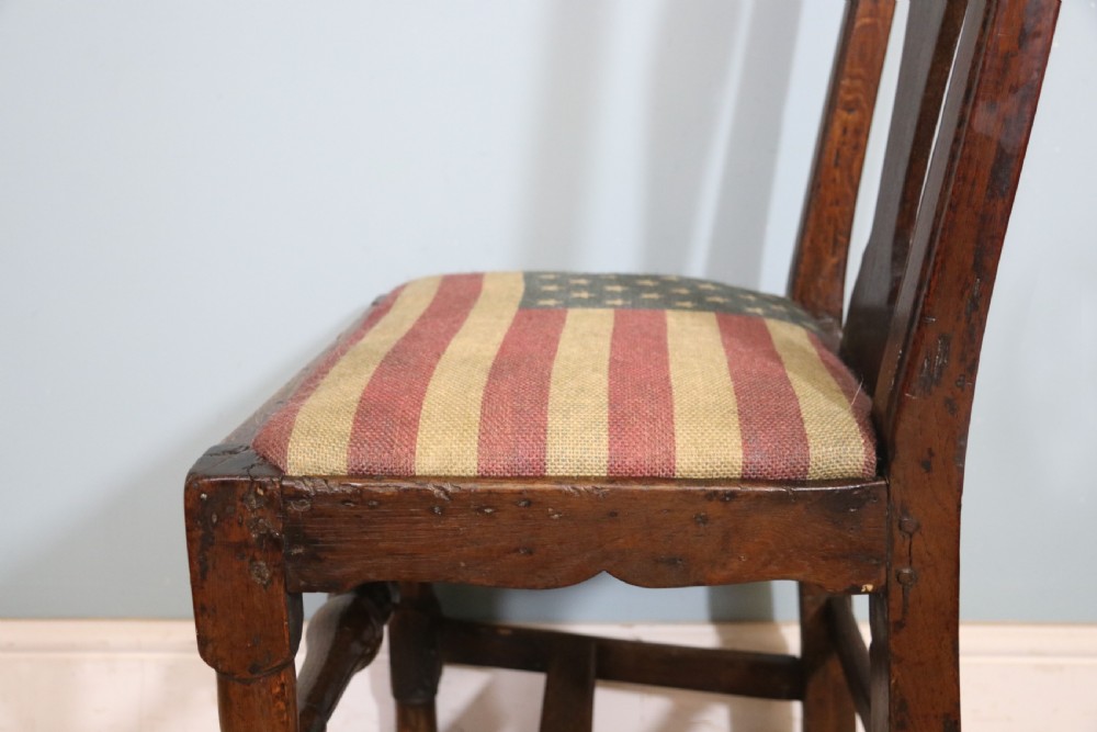 A pair of dark oak side chairs featuring vasiform back splats, turned front stretchers, and seats upholstered in an American flag pattern fabric. View XV