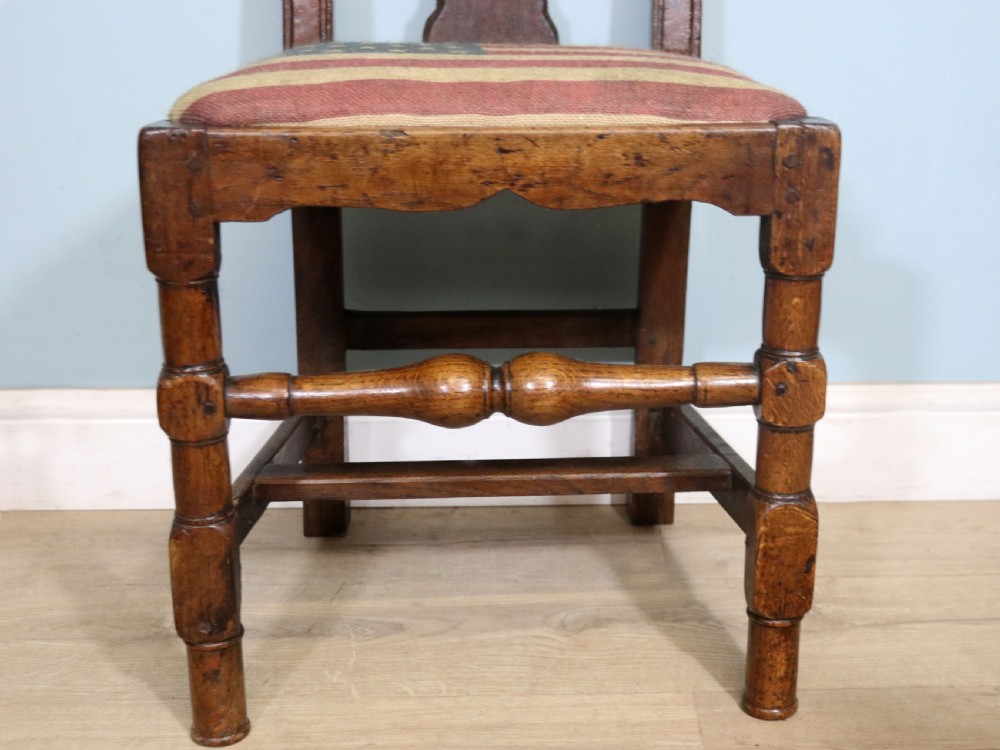 A pair of dark oak side chairs featuring vasiform back splats, turned front stretchers, and seats upholstered in an American flag pattern fabric. View XVI