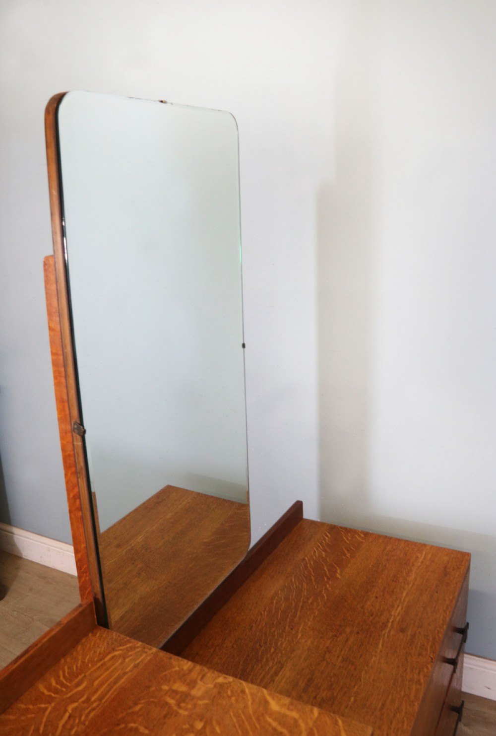 An asymmetrical golden oak dressing chest with a left-hand side cupboard, two drawers on the right, metal handles, and an off-centre tall mirror. View IX