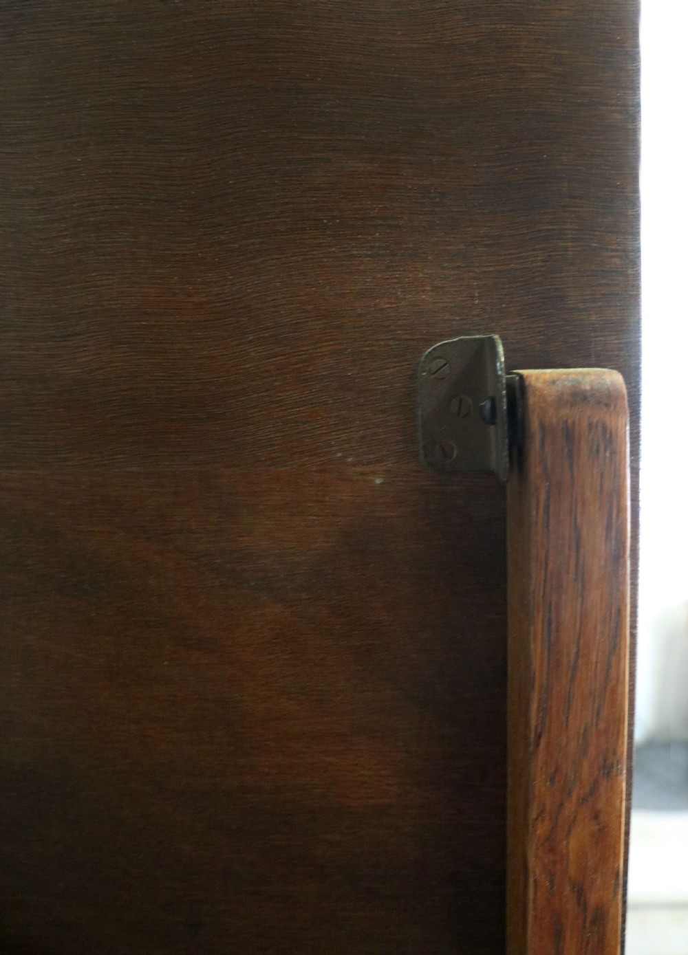An asymmetrical golden oak dressing chest with a left-hand side cupboard, two drawers on the right, metal handles, and an off-centre tall mirror. View XIII