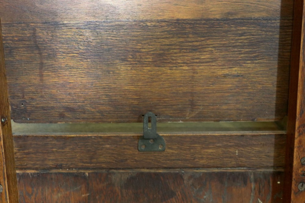 An asymmetrical golden oak dressing chest with a left-hand side cupboard, two drawers on the right, metal handles, and an off-centre tall mirror. View XV