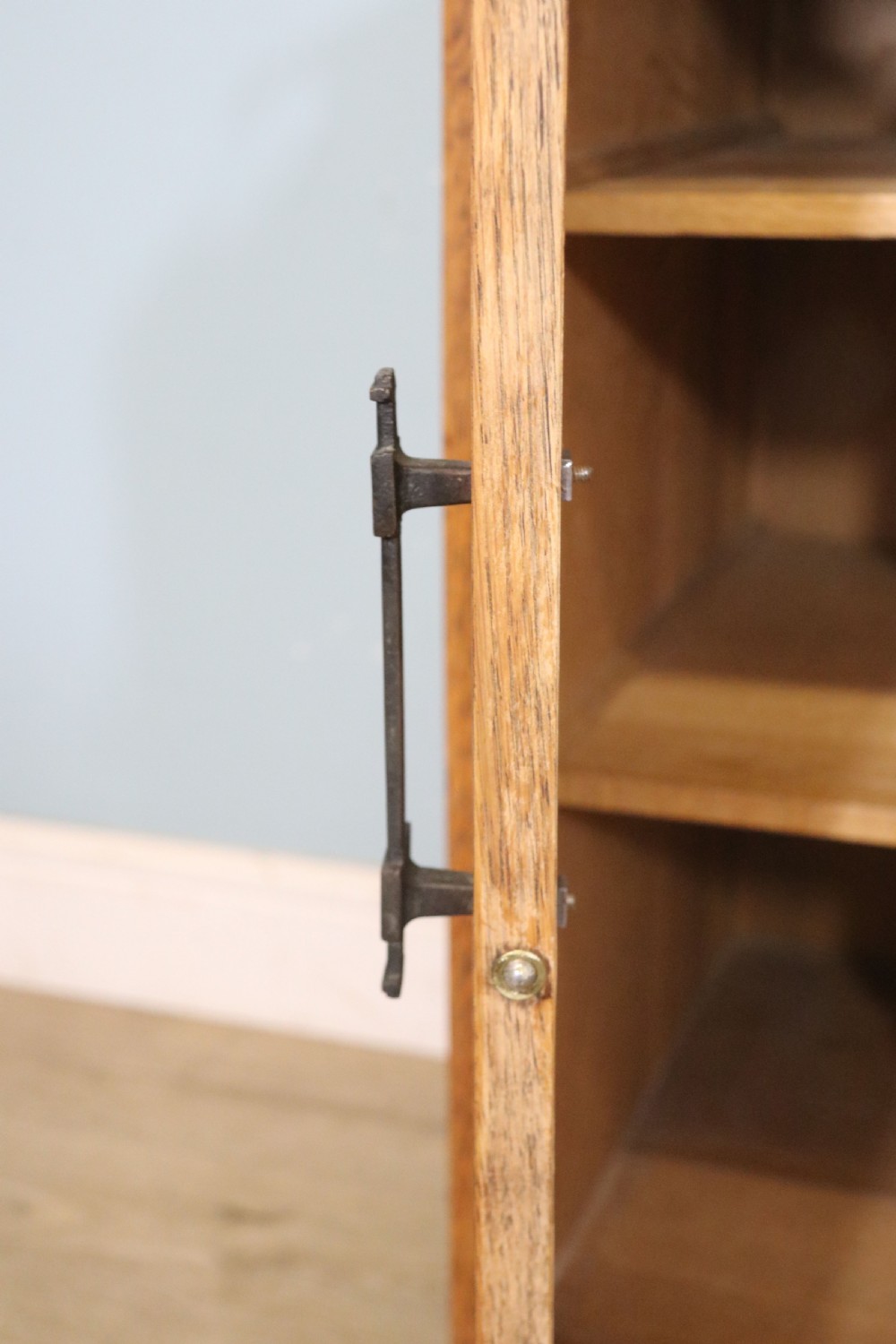 An asymmetrical golden oak dressing chest with a left-hand side cupboard, two drawers on the right, metal handles, and an off-centre tall mirror. View XXI
