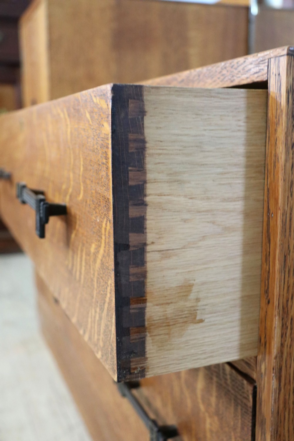 An asymmetrical golden oak dressing chest with a left-hand side cupboard, two drawers on the right, metal handles, and an off-centre tall mirror. View XXII