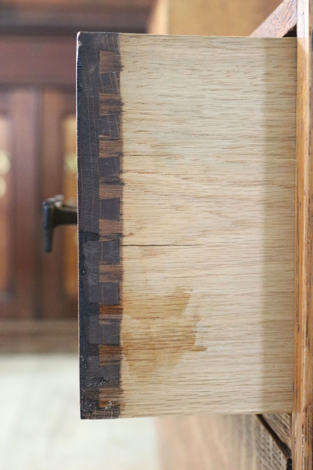 An asymmetrical golden oak dressing chest with a left-hand side cupboard, two drawers on the right, metal handles, and an off-centre tall mirror. View XXIII