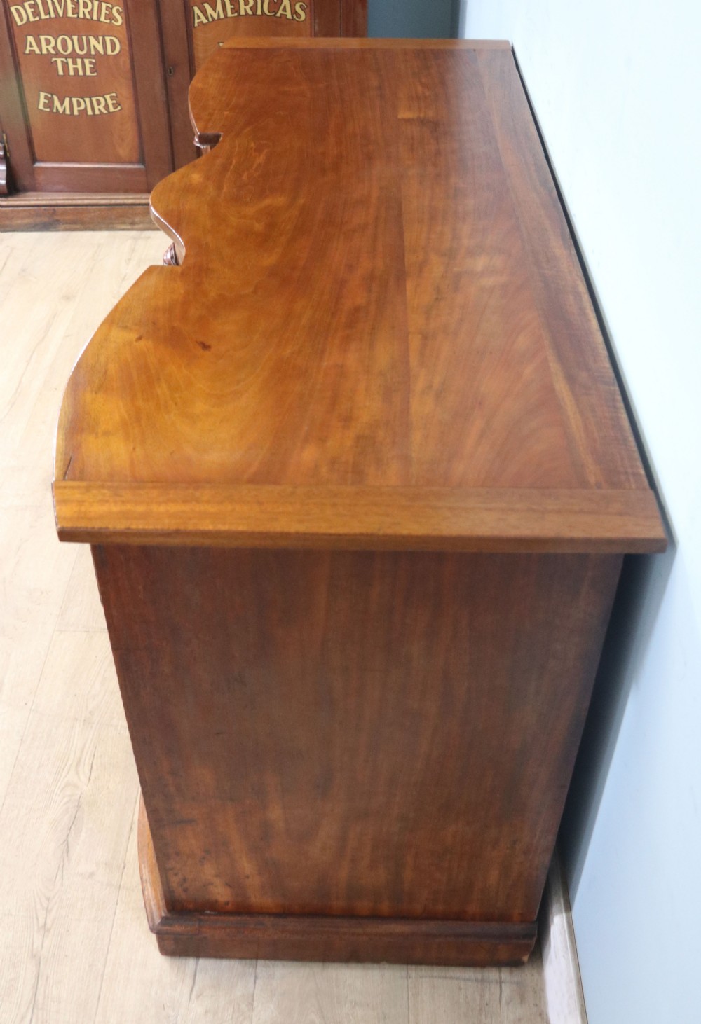 A late Victorian mahogany twin pedestal desk featuring a curved front structure and nine drawers with turned wooden handles. View VII
