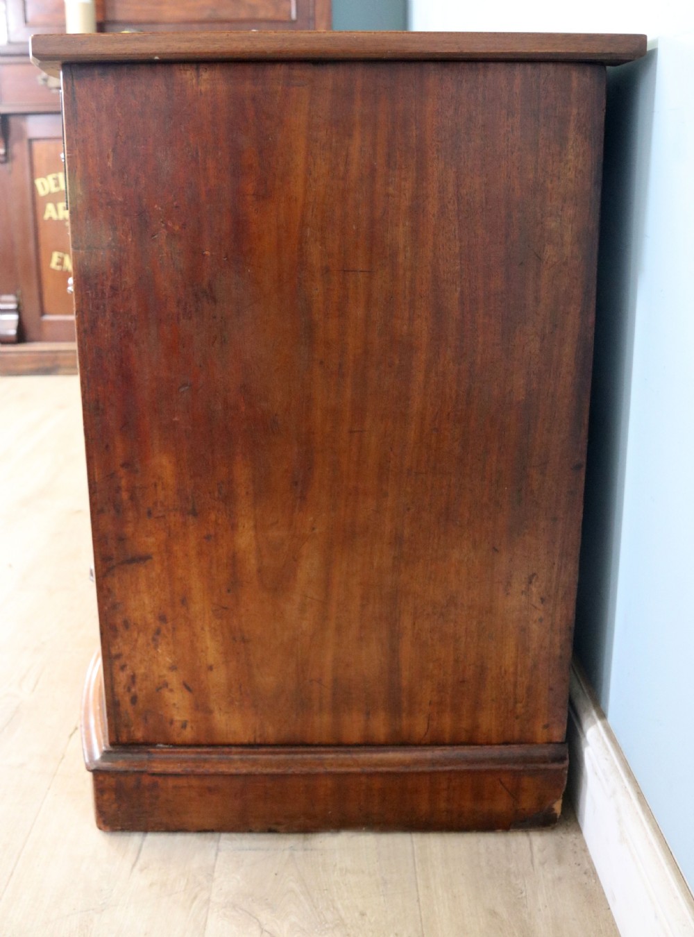 A late Victorian mahogany twin pedestal desk featuring a curved front structure and nine drawers with turned wooden handles. View XVI