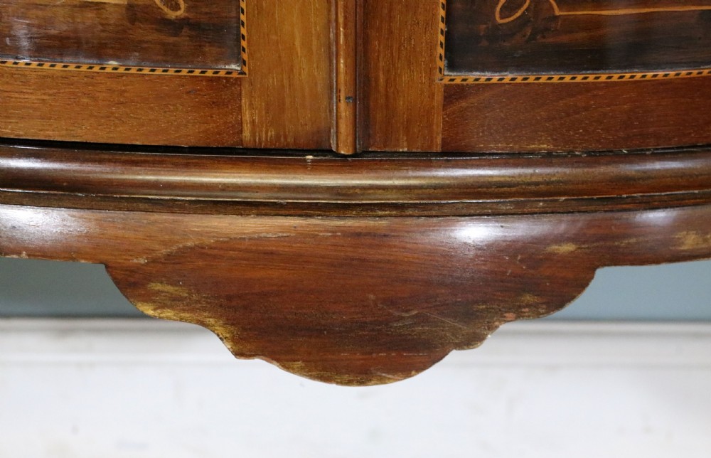 An Edwardian mahogany and satinwood display cabinet featuring curved glass doors decorated with French text and painted floral motifs, resting on slender cabriole legs. View XXIV
