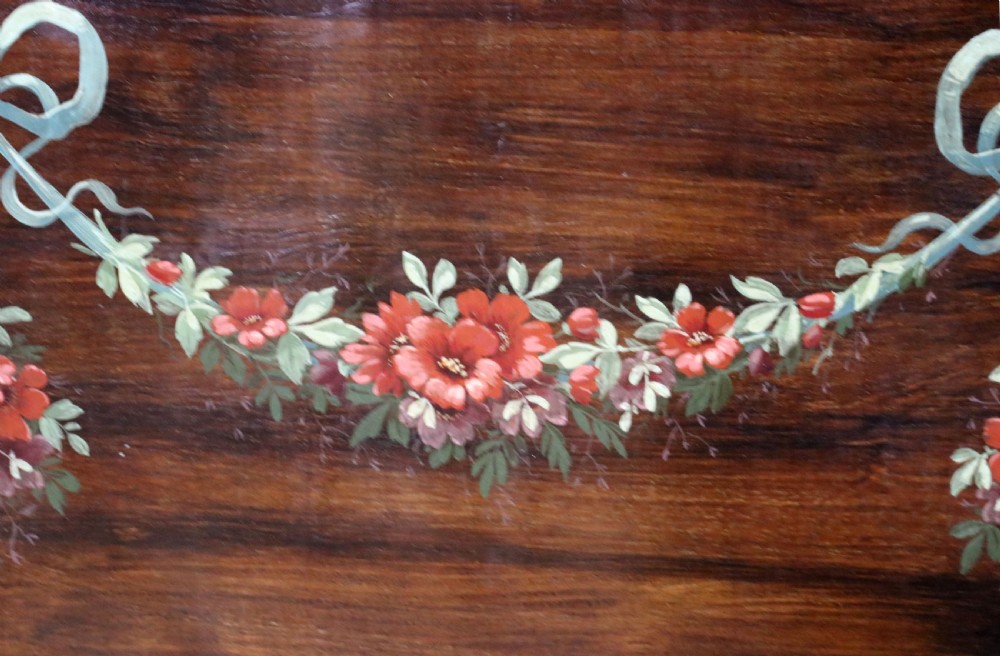 An Edwardian mahogany and satinwood display cabinet featuring curved glass doors decorated with French text and painted floral motifs, resting on slender cabriole legs. View XXVI