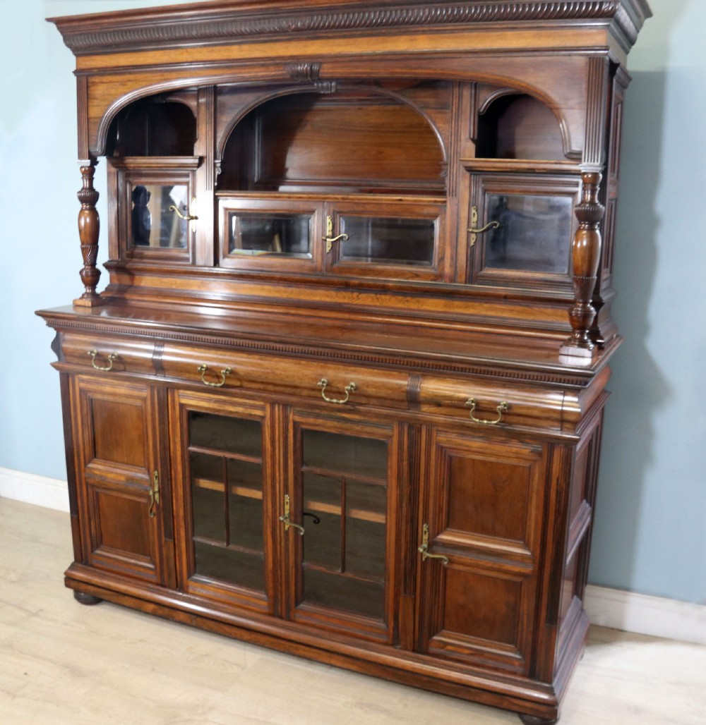 A large Victorian rosewood sideboard featuring an upper tier with arched alcoves, mirrors, and glazed cabinets over a lower base with drawers and panelled doors. View II