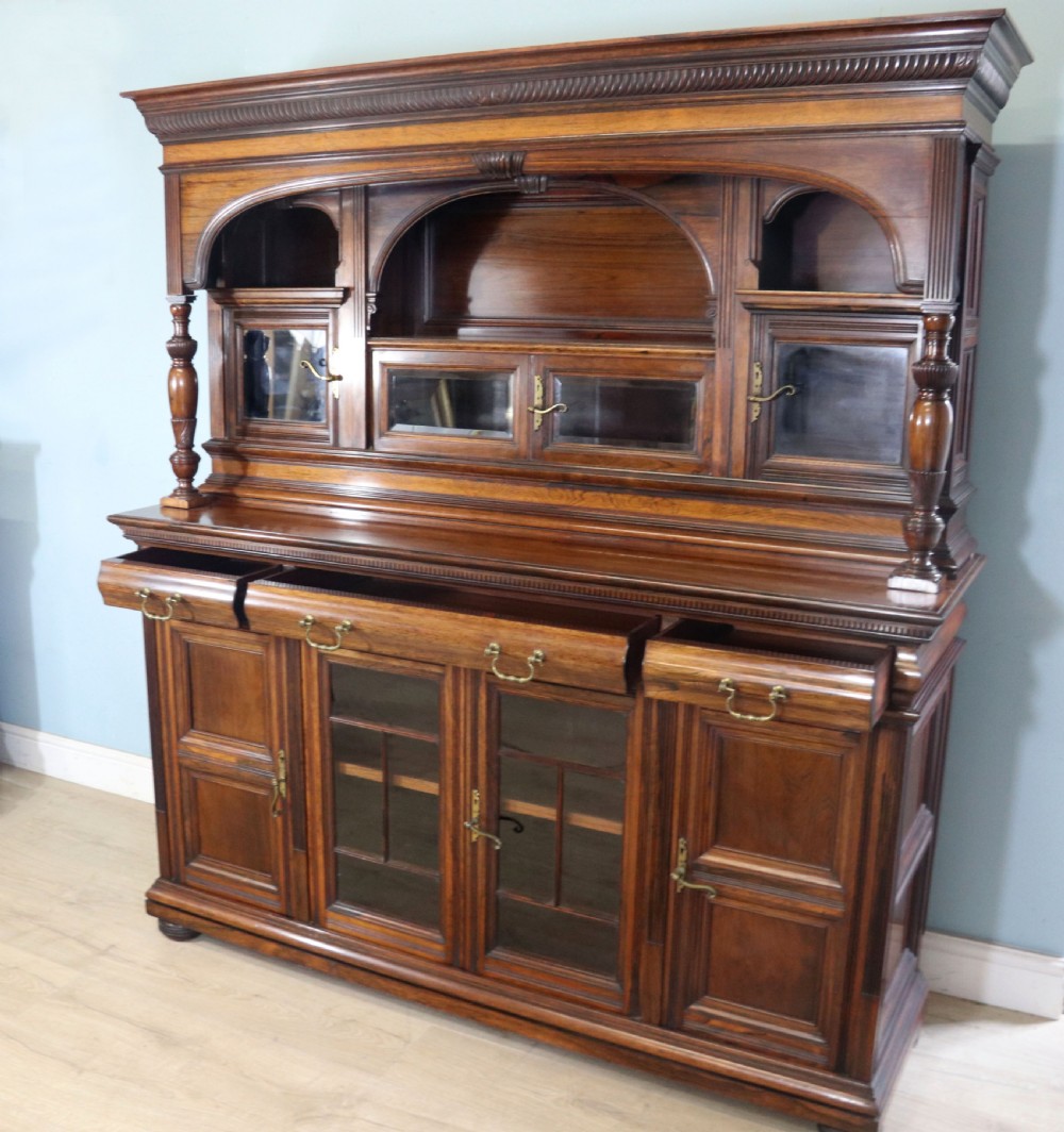 A large Victorian rosewood sideboard featuring an upper tier with arched alcoves, mirrors, and glazed cabinets over a lower base with drawers and panelled doors. View IV