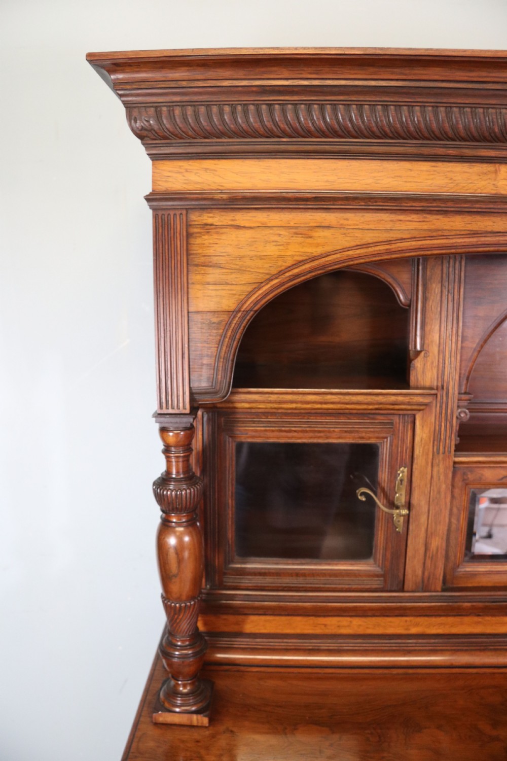 A large Victorian rosewood sideboard featuring an upper tier with arched alcoves, mirrors, and glazed cabinets over a lower base with drawers and panelled doors. View VIII