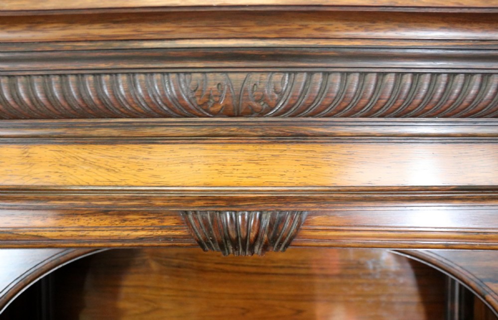 A large Victorian rosewood sideboard featuring an upper tier with arched alcoves, mirrors, and glazed cabinets over a lower base with drawers and panelled doors. View XI