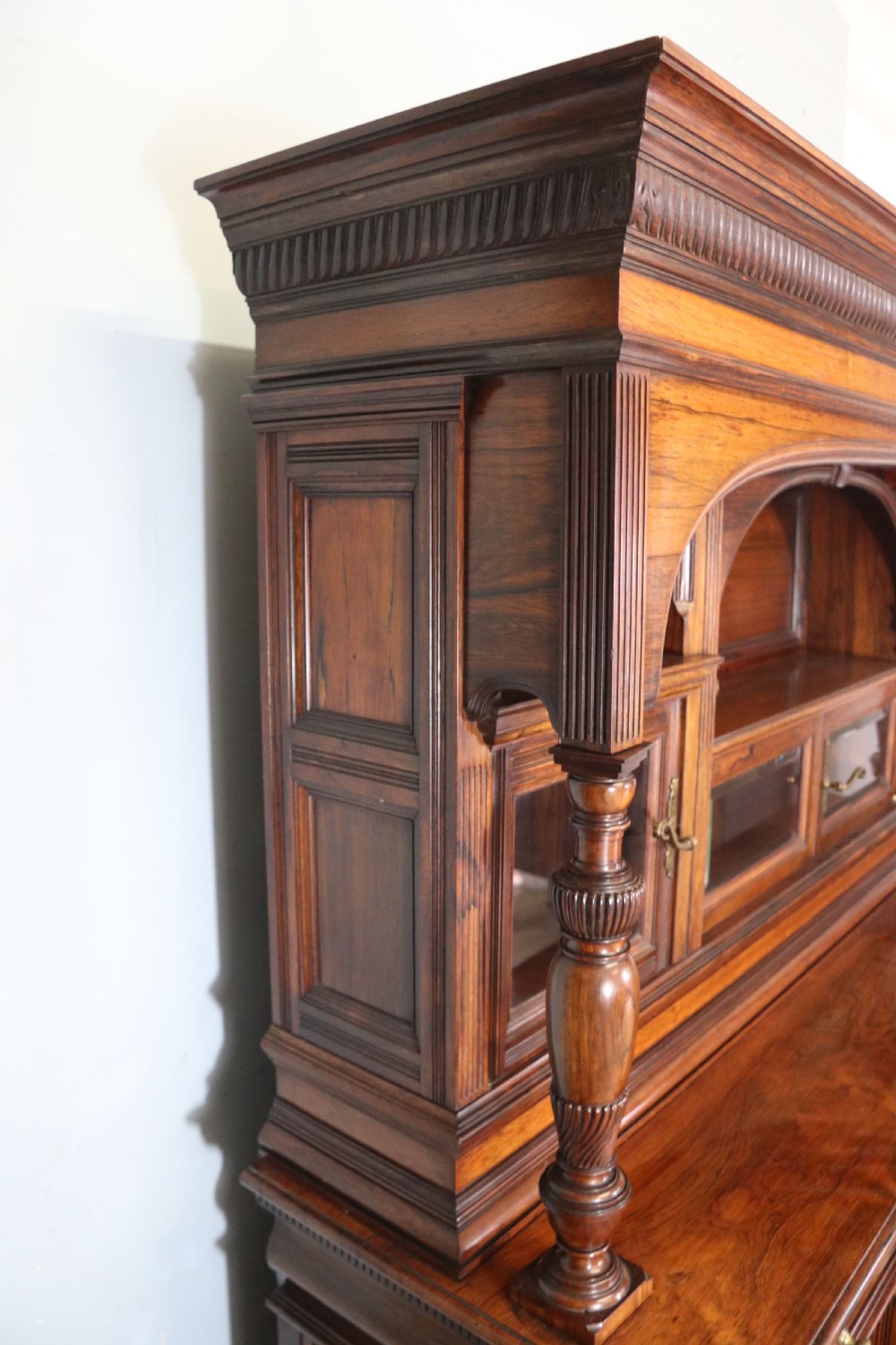 A large Victorian rosewood sideboard featuring an upper tier with arched alcoves, mirrors, and glazed cabinets over a lower base with drawers and panelled doors. View XIV
