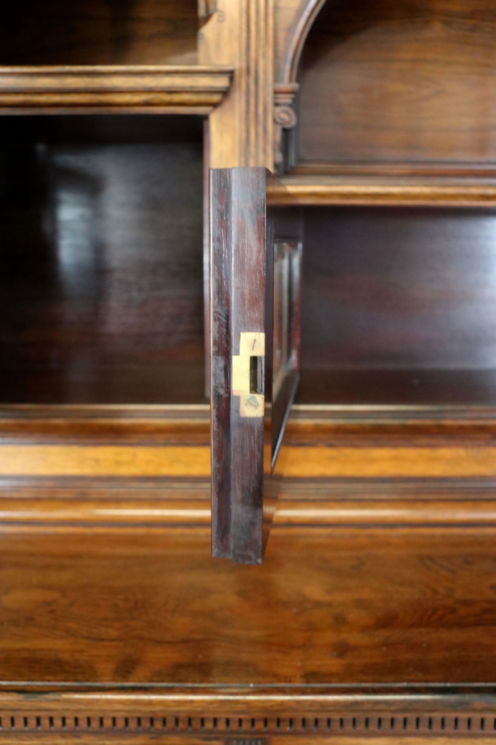 A large Victorian rosewood sideboard featuring an upper tier with arched alcoves, mirrors, and glazed cabinets over a lower base with drawers and panelled doors. View XVI