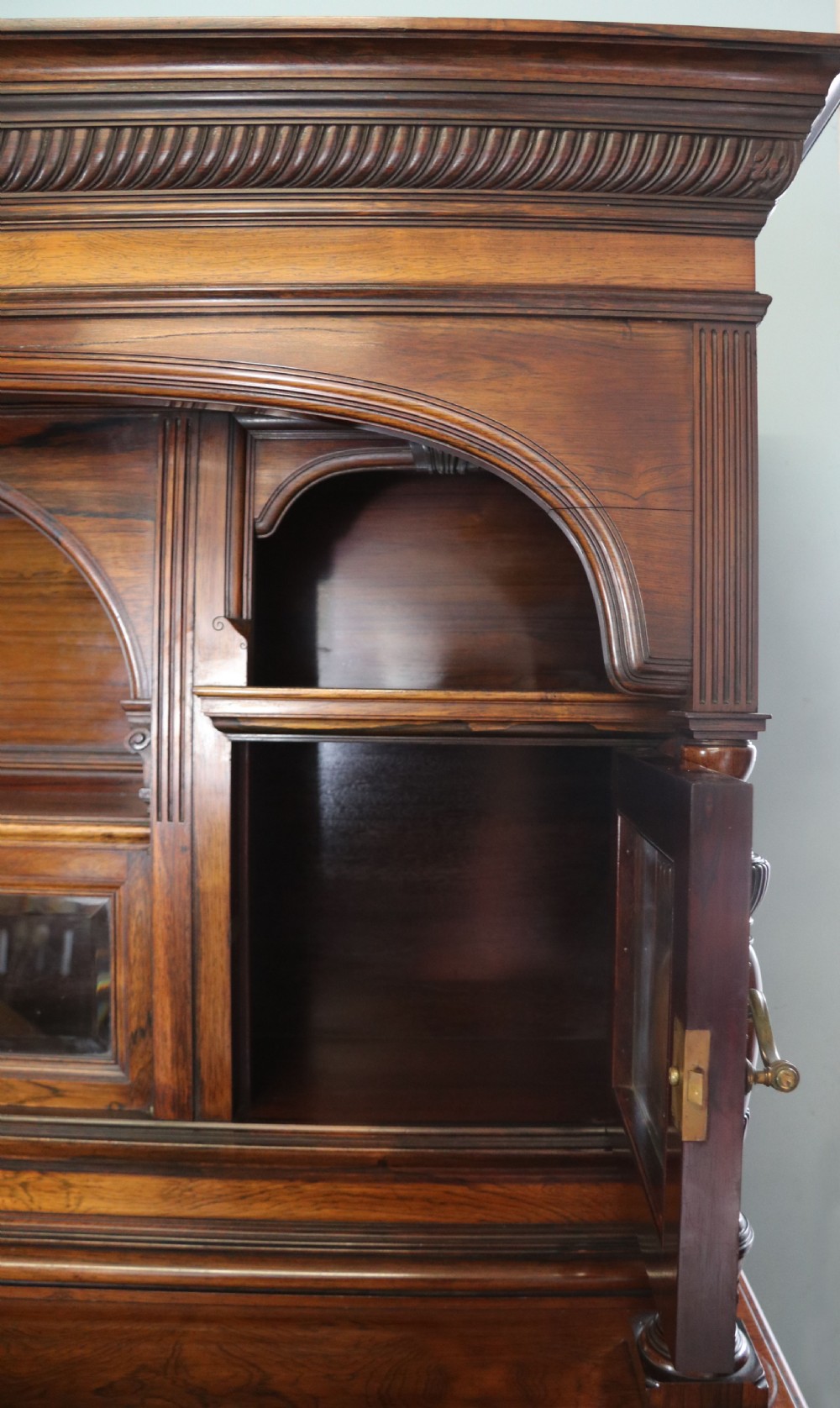 A large Victorian rosewood sideboard featuring an upper tier with arched alcoves, mirrors, and glazed cabinets over a lower base with drawers and panelled doors. View XIX
