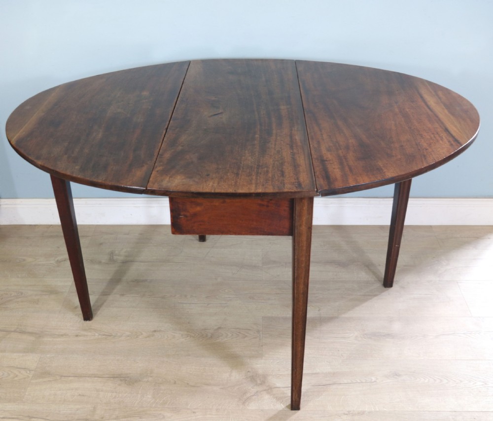George III mahogany dropleaf table of oval form