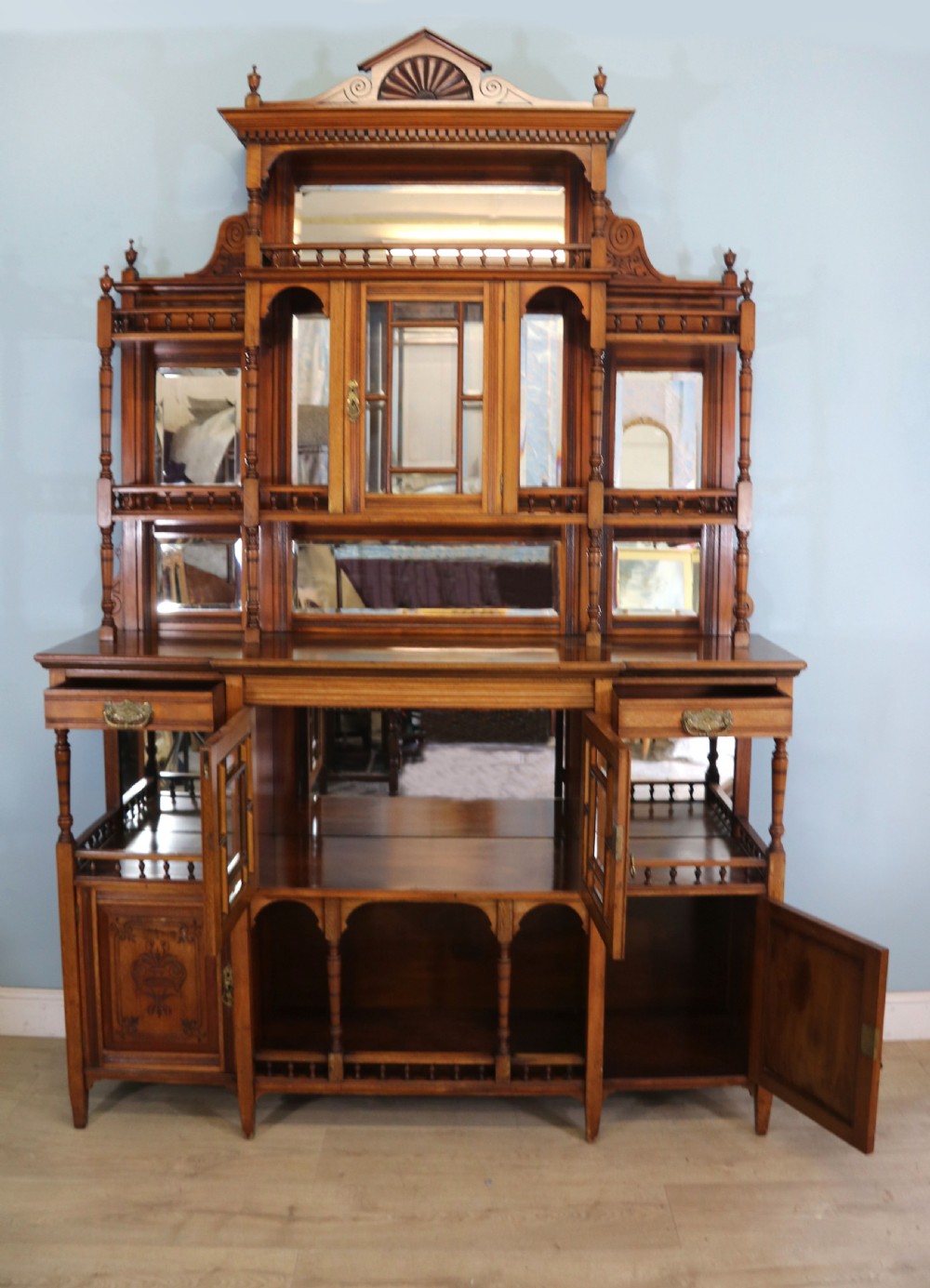 A late Victorian carved wood side cabinet featuring an ornate upper tier with multiple bevelled mirror plates, spindled galleries, glass-front doors, and carved lower cupboards. View III