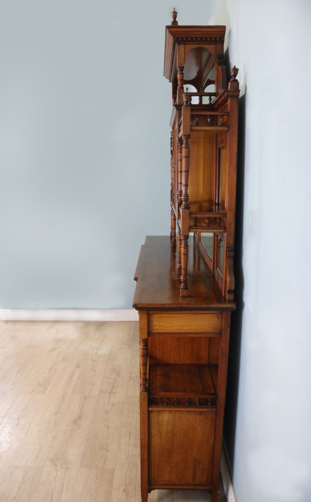 A late Victorian carved wood side cabinet featuring an ornate upper tier with multiple bevelled mirror plates, spindled galleries, glass-front doors, and carved lower cupboards. View V