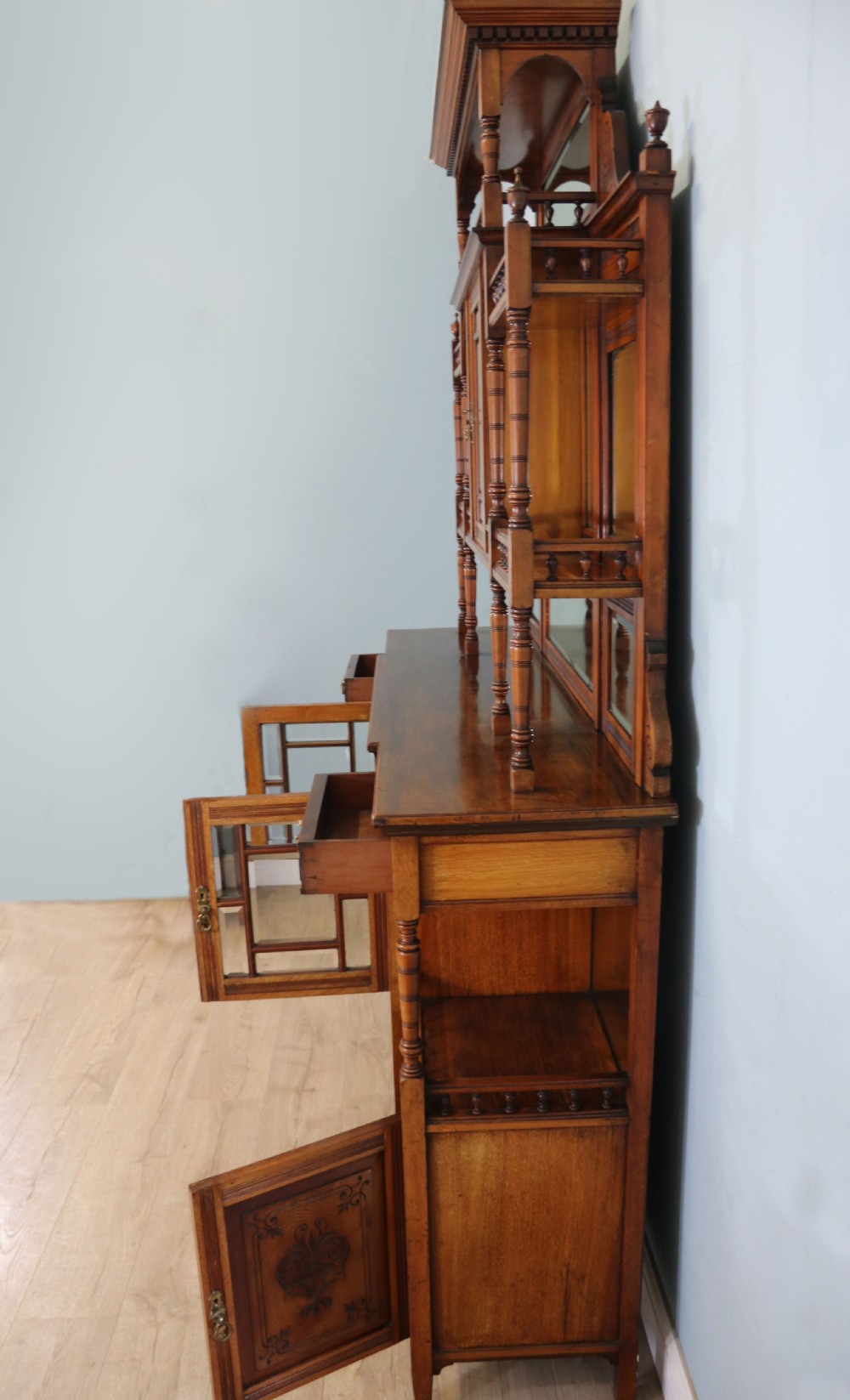 A late Victorian carved wood side cabinet featuring an ornate upper tier with multiple bevelled mirror plates, spindled galleries, glass-front doors, and carved lower cupboards. View VII