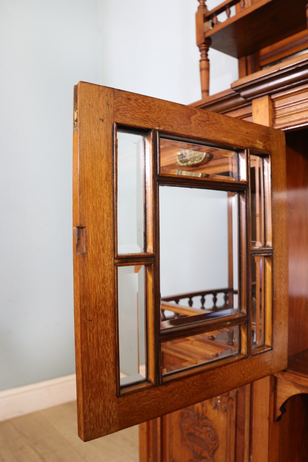 A late Victorian carved wood side cabinet featuring an ornate upper tier with multiple bevelled mirror plates, spindled galleries, glass-front doors, and carved lower cupboards. View XX