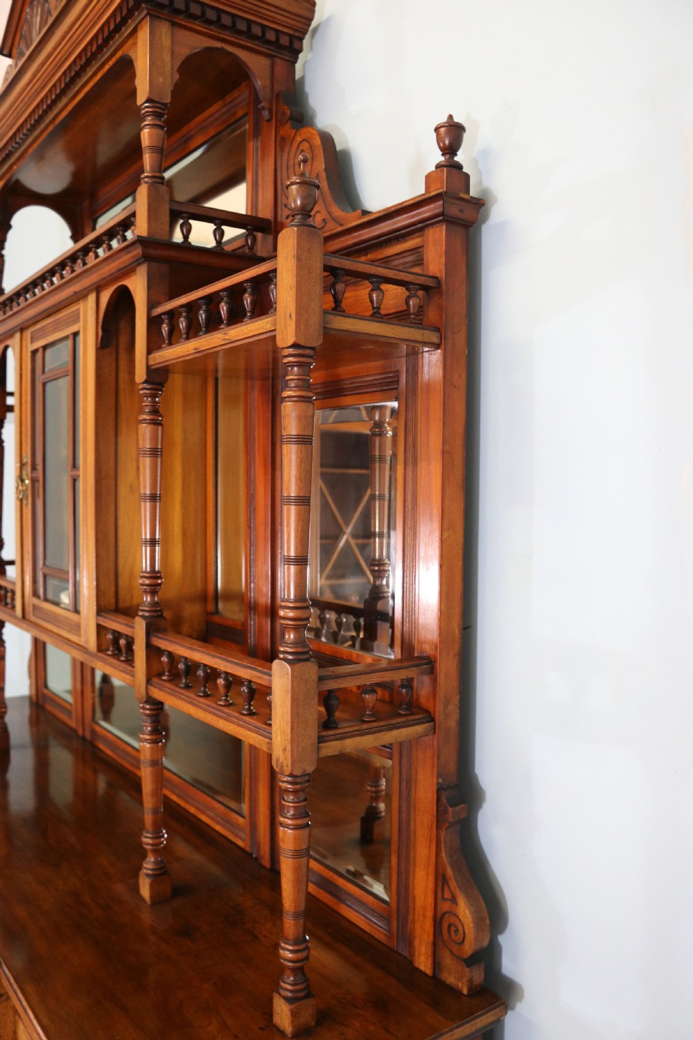 A late Victorian carved wood side cabinet featuring an ornate upper tier with multiple bevelled mirror plates, spindled galleries, glass-front doors, and carved lower cupboards. View XXIX