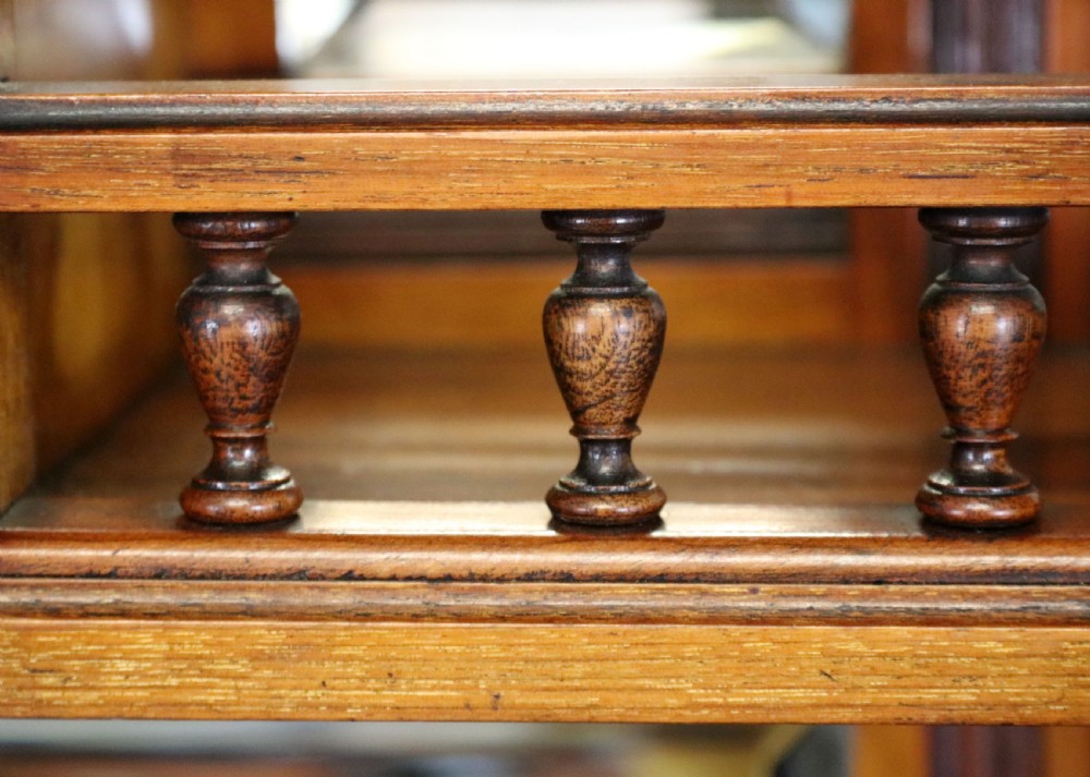 A late Victorian carved wood side cabinet featuring an ornate upper tier with multiple bevelled mirror plates, spindled galleries, glass-front doors, and carved lower cupboards. View XXX