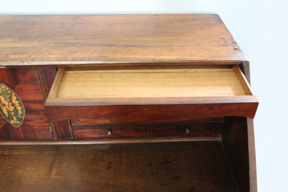 An open George III oak bureau featuring mahogany crossbanding, brass swan-neck handles, pull-out lopers, and a fitted interior with pigeonholes. View VIII