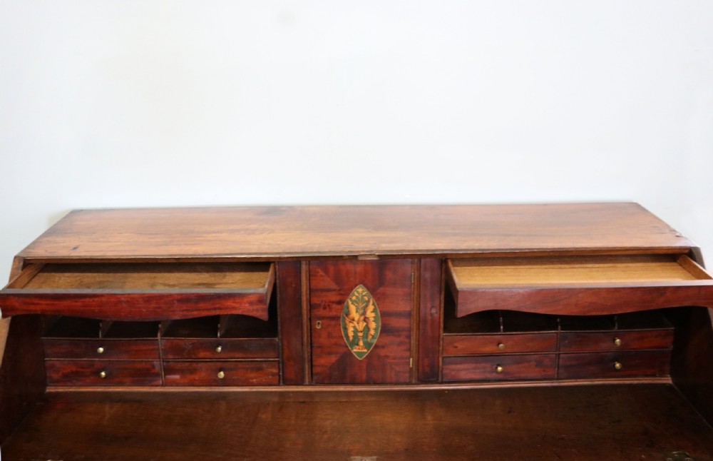 An open George III oak bureau featuring mahogany crossbanding, brass swan-neck handles, pull-out lopers, and a fitted interior with pigeonholes. View X