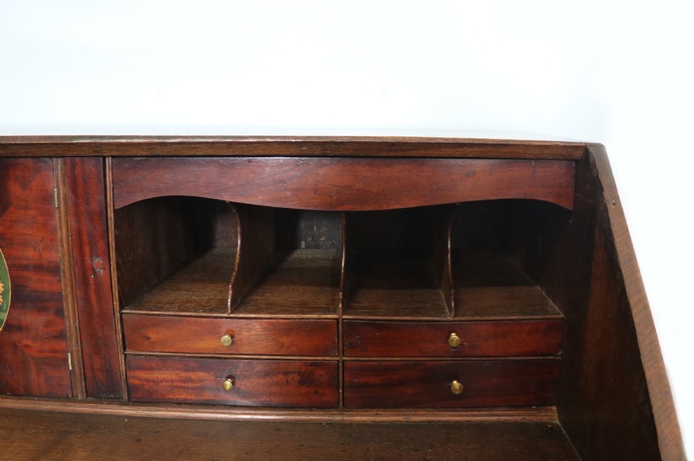An open George III oak bureau featuring mahogany crossbanding, brass swan-neck handles, pull-out lopers, and a fitted interior with pigeonholes. View XI
