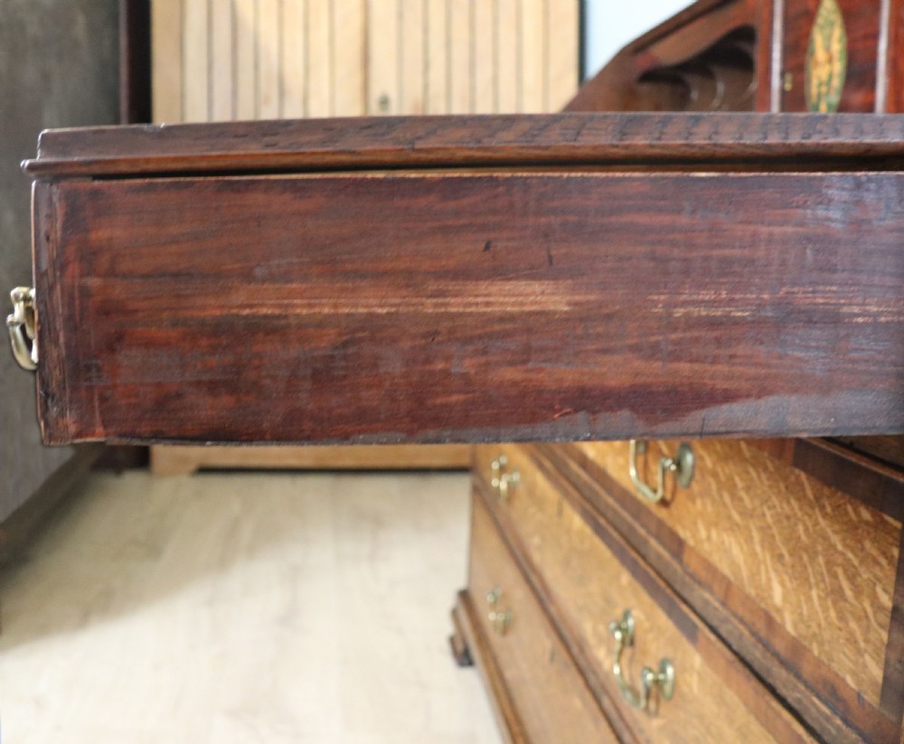 An open George III oak bureau featuring mahogany crossbanding, brass swan-neck handles, pull-out lopers, and a fitted interior with pigeonholes. View XVII