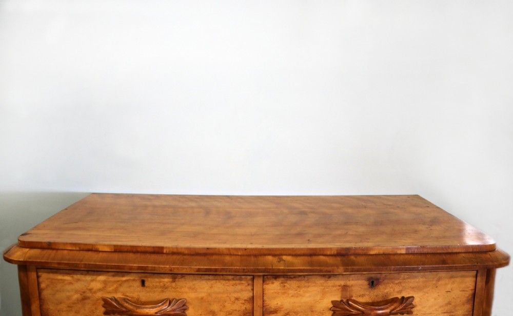 A Victorian light wood chest of drawers with two short drawers over three long drawers, featuring carved leaf handles and a solid plinth base. View IV