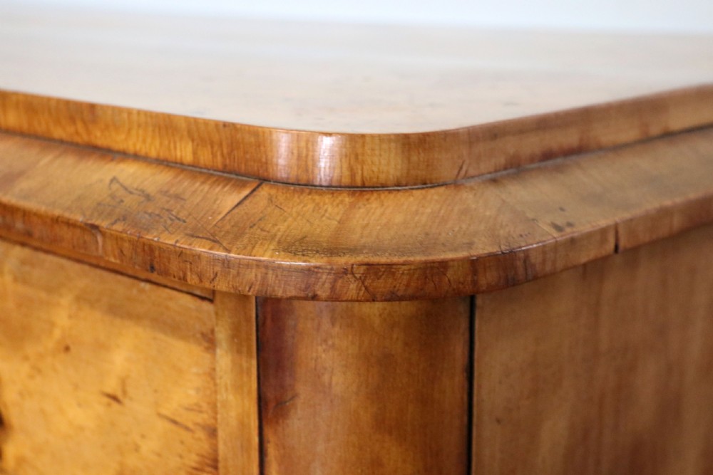 A Victorian light wood chest of drawers with two short drawers over three long drawers, featuring carved leaf handles and a solid plinth base. View VI