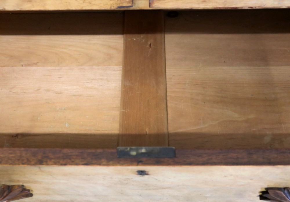 A Victorian light wood chest of drawers with two short drawers over three long drawers, featuring carved leaf handles and a solid plinth base. View XV