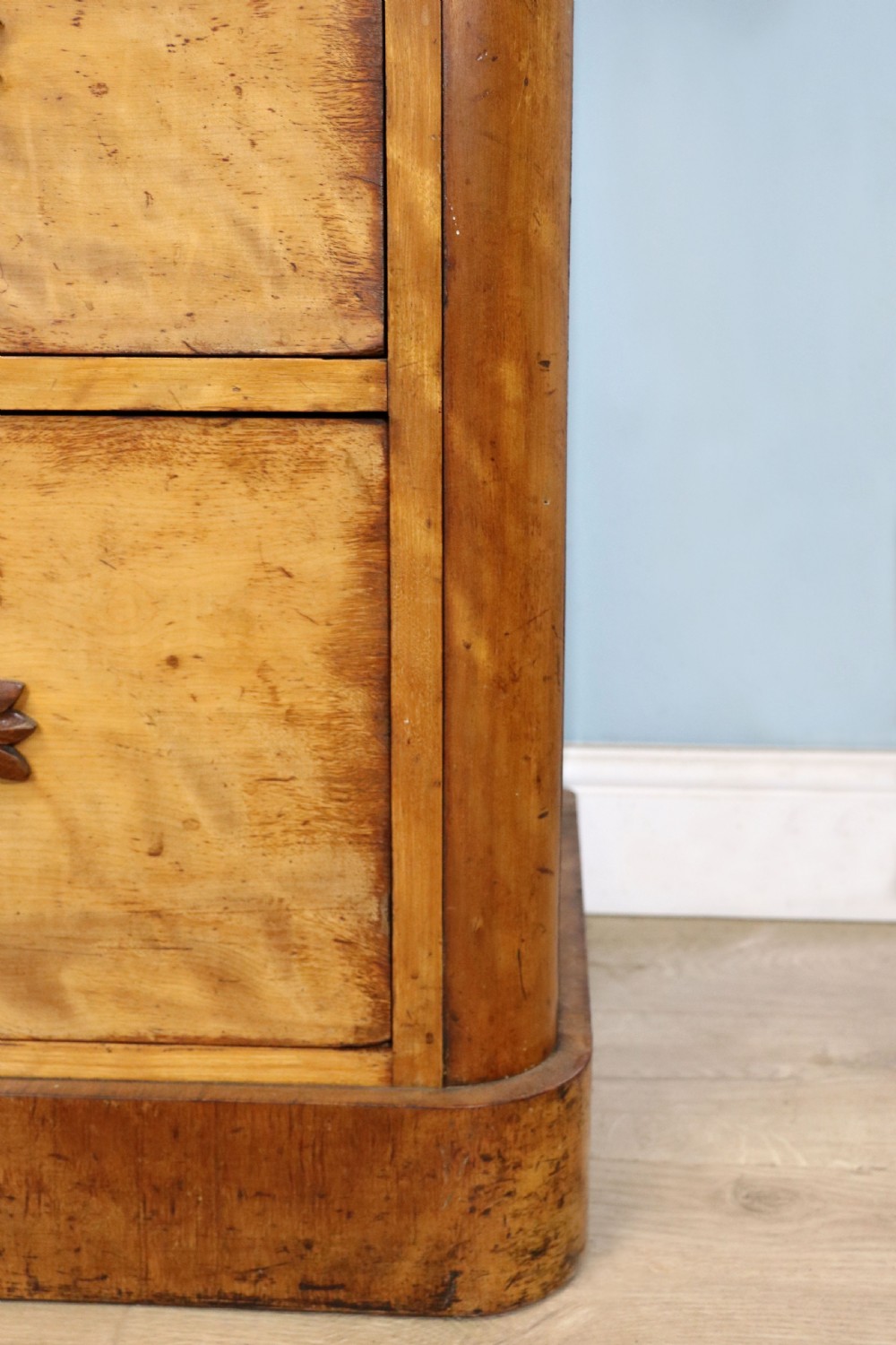 A Victorian light wood chest of drawers with two short drawers over three long drawers, featuring carved leaf handles and a solid plinth base. View XVI