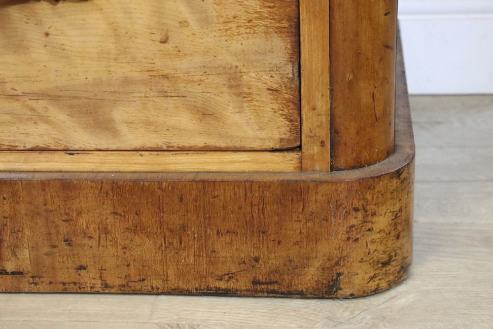 A Victorian light wood chest of drawers with two short drawers over three long drawers, featuring carved leaf handles and a solid plinth base. View XVII