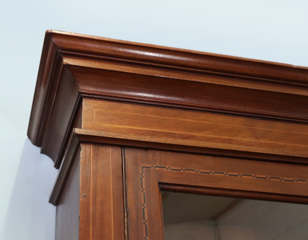 A late Victorian warm brown wooden cabinet featuring a glazed upper display section with white Jack Daniels typography and two lower panelled doors. View IX