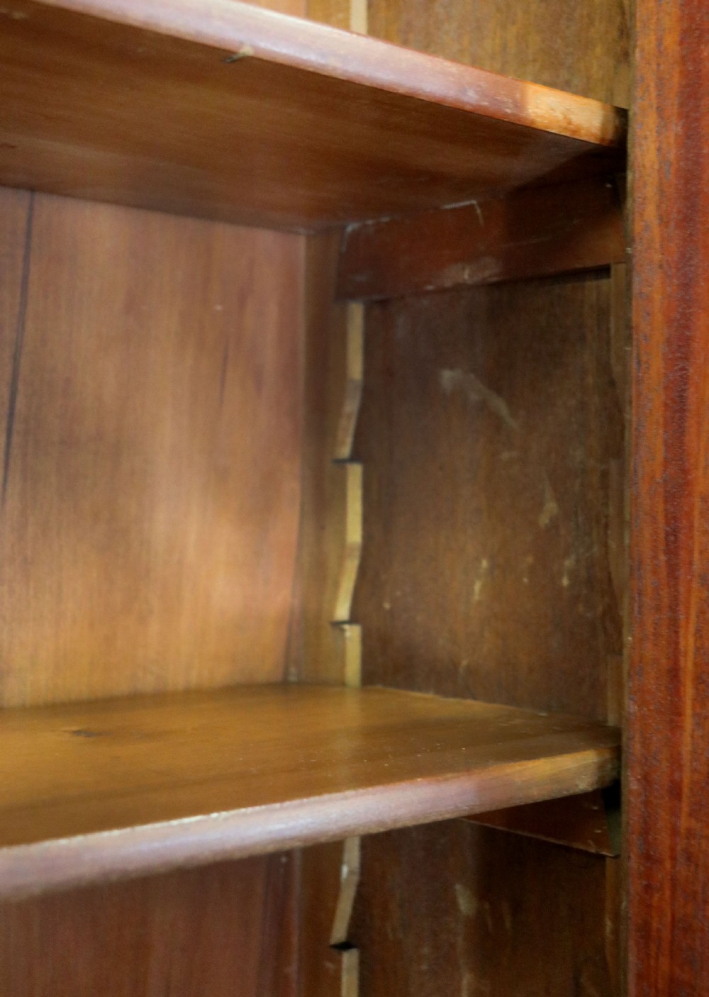 A late Victorian warm brown wooden cabinet featuring a glazed upper display section with white Jack Daniels typography and two lower panelled doors. View XX