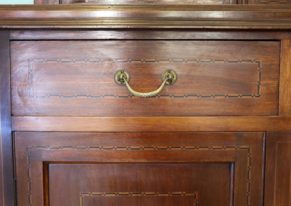 A late Victorian warm brown wooden cabinet featuring a glazed upper display section with white Jack Daniels typography and two lower panelled doors. View XXI