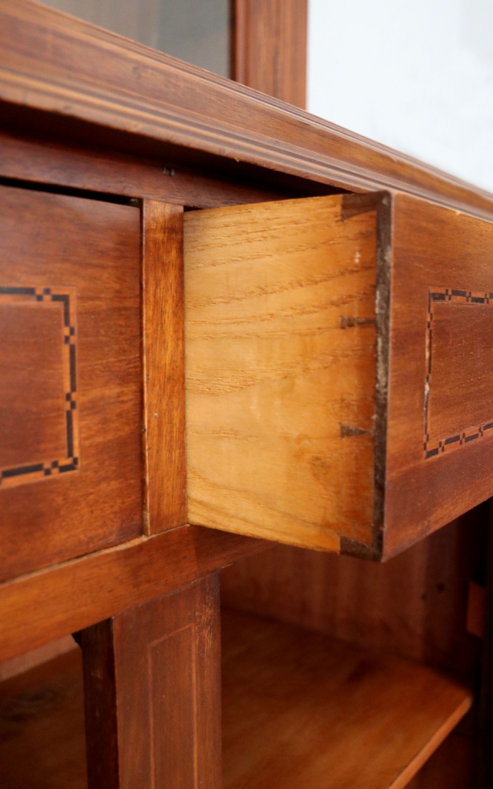 A late Victorian warm brown wooden cabinet featuring a glazed upper display section with white Jack Daniels typography and two lower panelled doors. View XXII